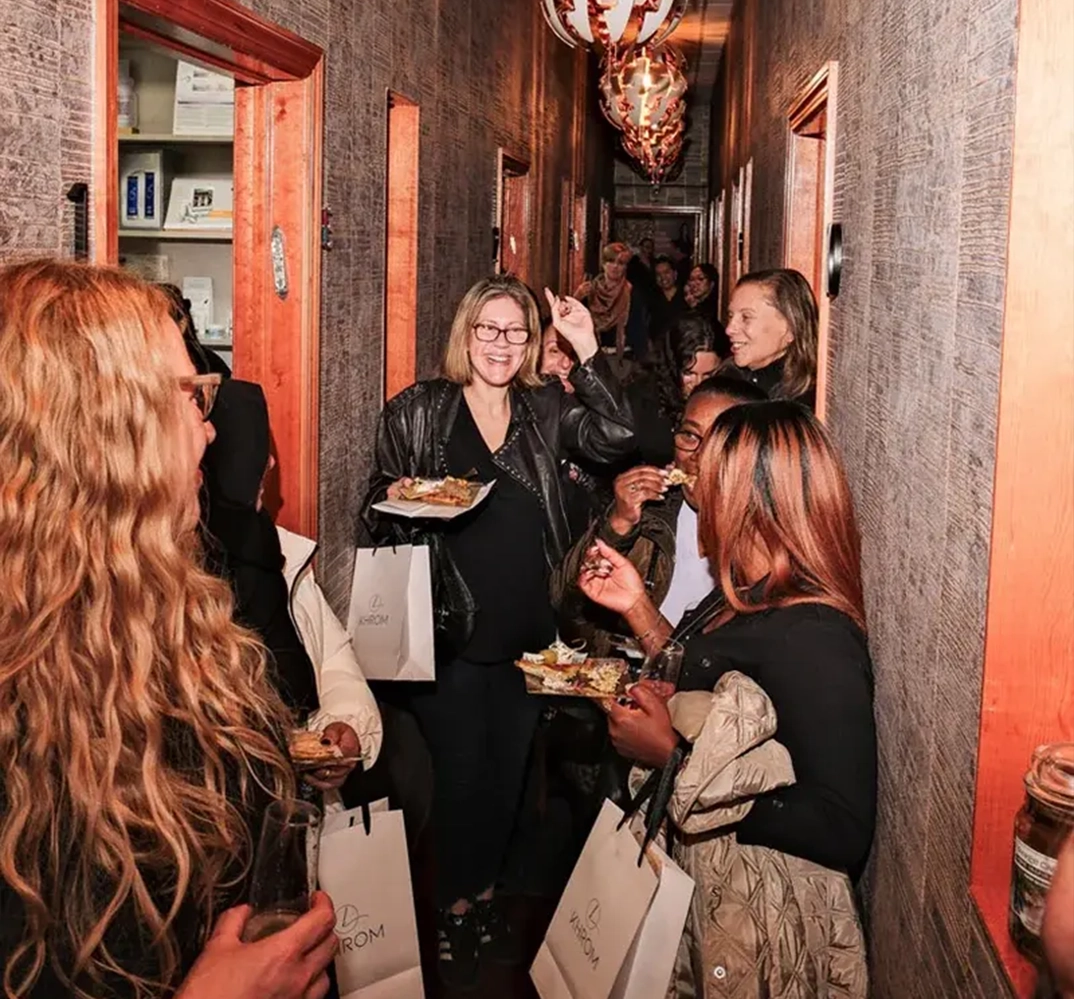 People socializing in a narrow hallway.