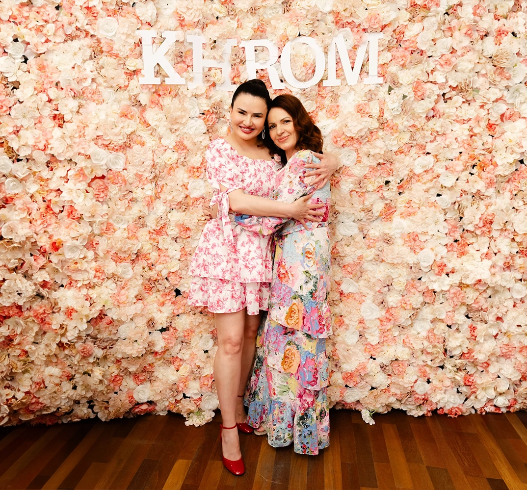 Two women posing in floral setting